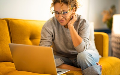 Woman smiles while looking at her computer