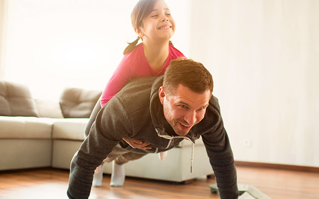 Man doing pushup with daughter on back